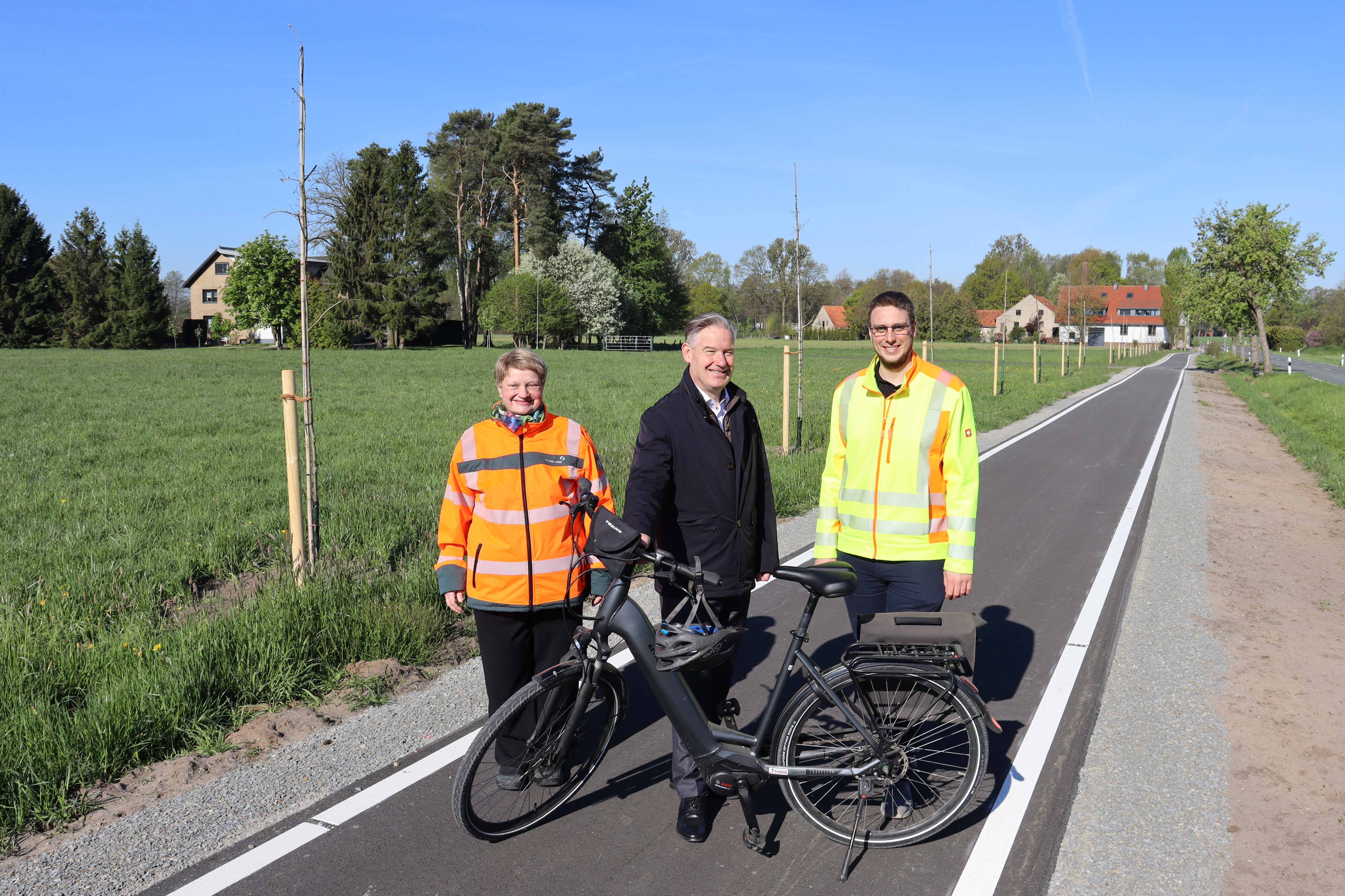 Kathrin Gellermann vom Landesbetrieb Stra�enbau NRW, B�rgermeister Michael Berens und Klimaschutzmanager Moritz Pucker auf dem fertiggestellten B�rgerradweg an der Espelner Stra�e. 