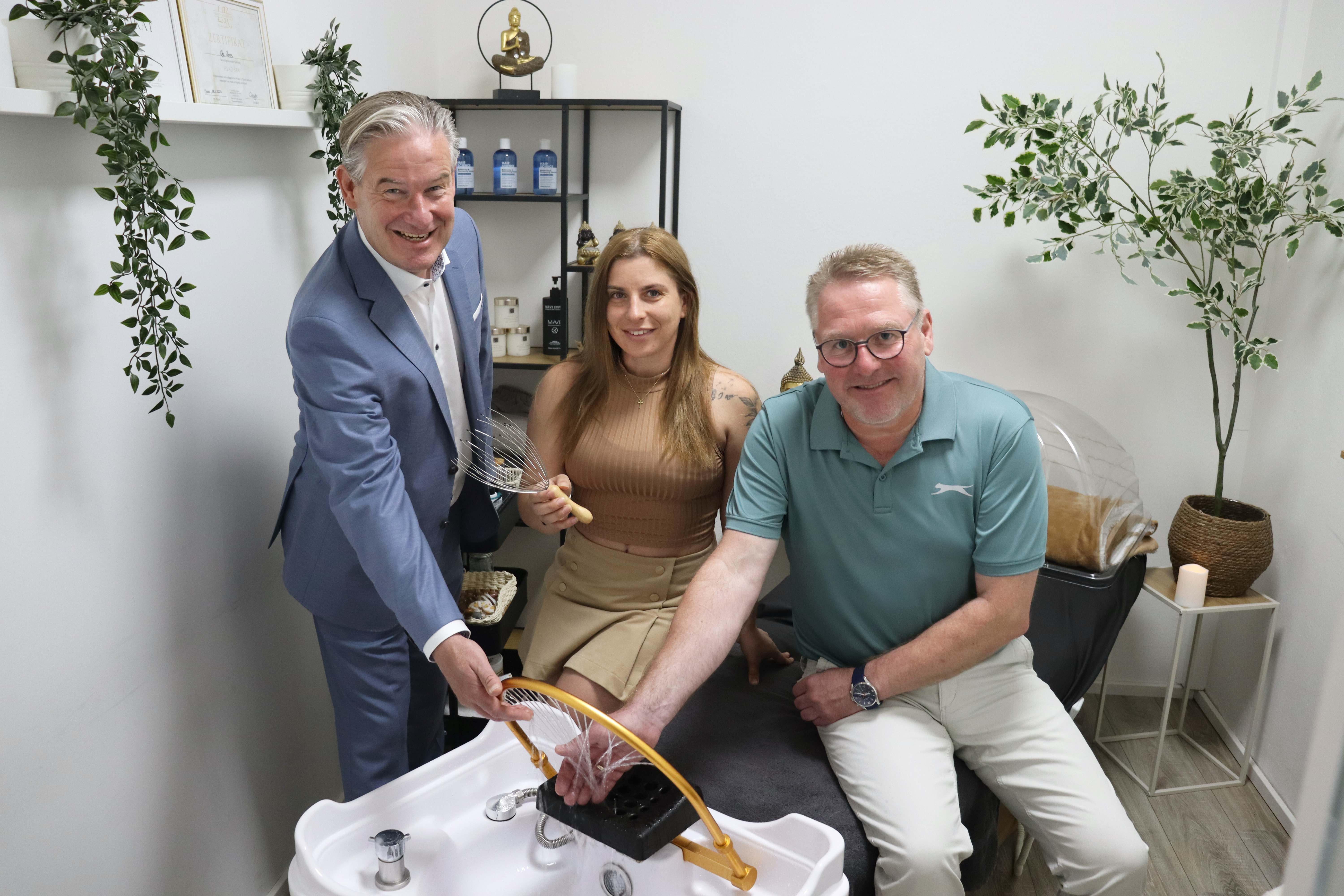 Wie eine Head Spa-Behandlung abl�uft, demonstrierte Olja Jones B�rgermeister Michael Berens (l.) und Wirtschaftsf�rderer Thomas Westhof bei ihrem Unternehmensbesuch in �Oljas Oase�. 
